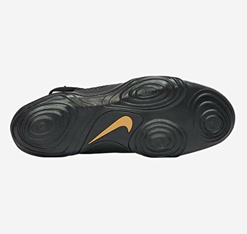 Bottom view of a black Nike shoe sole with orange logo.